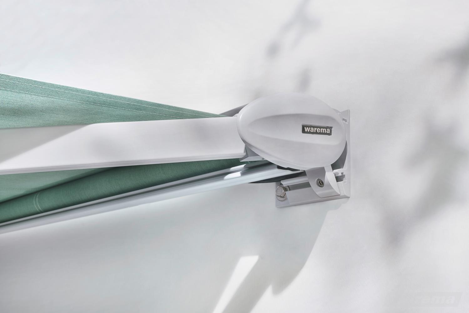 Nahaufnahme einer WAREMA Markise mit grünem Stoff, der aufgerollt ist, und einem weißen, modernen Markisenmotor.