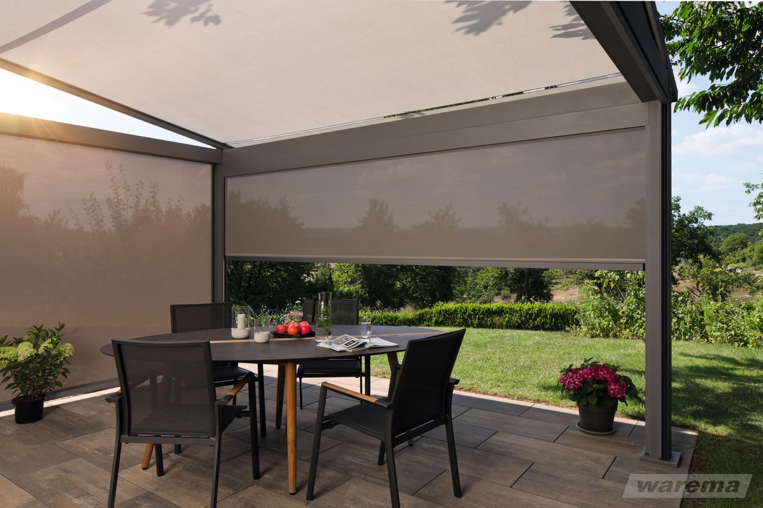 Moderne Pergola mit Markisenbeschattung und senkrechten Seitenmarkisen über einem Esstisch im Garten, idealer Sonnenschutz mit Blick ins Grüne.